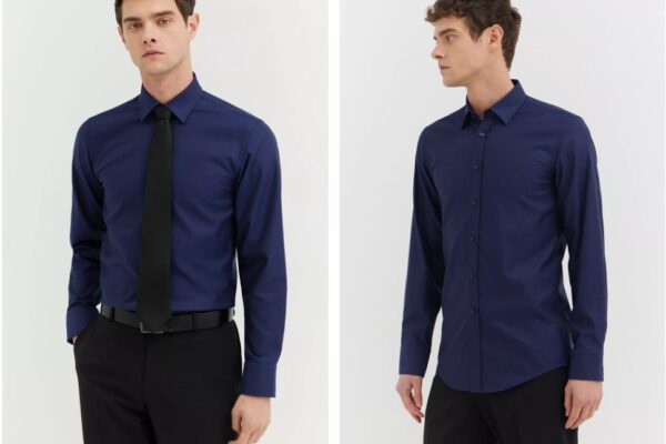 mężczyzna w granatowej koszuli z czarnym krawatem, stoi na białym tle